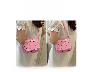 Pink saddle bag with cherry print showing crossbody and shoulder wearing styles