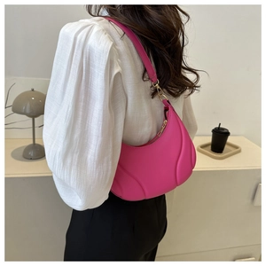 Detailed view of bright pink baguette bag featuring unique curved embossed wave patterns