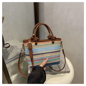 Détail de sac seau tressé multicolore avec poignées en similicuir marron élégant