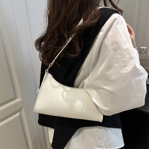 White glossy leather hobo underarm bag with zipper closure shown on model shoulder