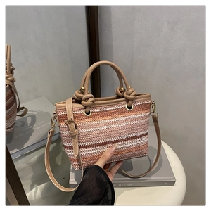 Détail du motif tissé multicolore sur un sac seau rayé avec poignée en cuir kaki