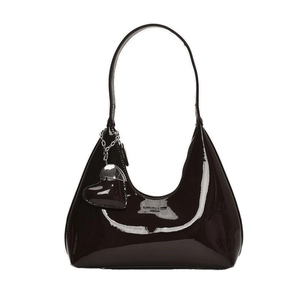 Minimalist black patent leather baguette bag with a heart charm and glossy finish
