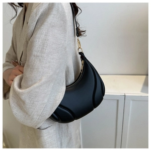 Detail of the black quilted leather half-moon bag featuring a gold zipper and matte finish