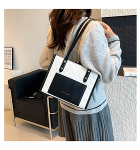 Detail view of contrast color tote bag with outer pocket and slim shoulder straps
