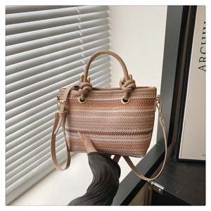 Détail d'un sac seau rayé tissé à la main avec poignée nouée et bandoulière en cuir