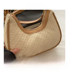 Close-up of the woven texture on the cream hobo bag with brown leather piping detail