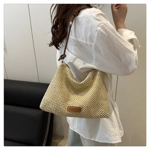 Dettaglio borsa a tracolla in paglia beige con cinturino in pelle marrone e patch FASHION