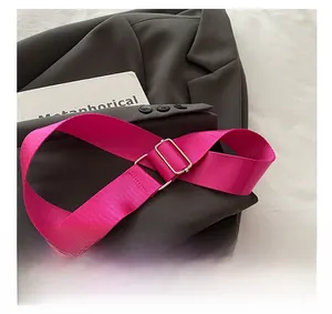 Detail of adjustable rose red woven shoulder strap with gold-tone rectangular buckle