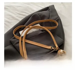 Detail of woven texture with brown leather strap and metal buckle on shoulder bag