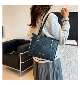 Detail of contrast stitch tote bag with textured weaving and smooth leather pocket