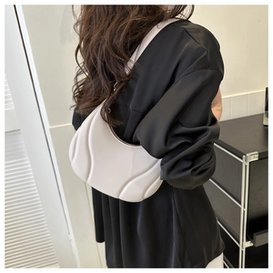 Detail of white pleated underarm bag with cloud-like puffed texture and minimalist PU leather