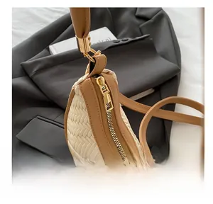 Close-up of smooth zipper and beige woven texture on the crescent shoulder bag
