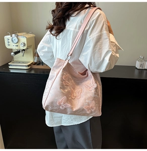 Detail der rosa bestickten Tragetasche mit 3D-Schmetterlingsapplikationen und Jacquard