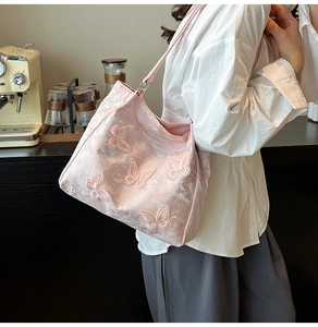 Detail der rosa bestickten Schmetterlings-Tasche mit floraler Spitze und Metall-Schnallenriemen