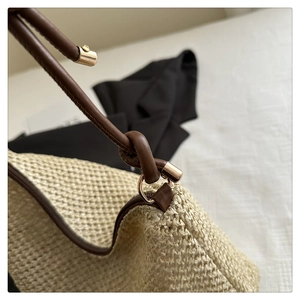 Dettaglio della borsa a spalla in paglia con trama beige e fibbia in ecopelle marrone scuro