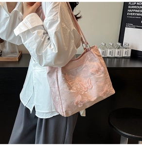 Nahaufnahme der rosa Schmetterlingsstickerei auf Jacquard-Stoff einer großen Tragetasche