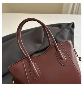 Detail of premium brown leather shoulder bag with reinforced stitching and gold D-ring
