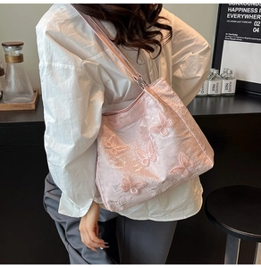 Detailansicht der rosa Tragetasche mit 3D-Schmetterlingsstickerei und Jacquard-Stoffstruktur