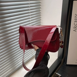 Glossy dark red patent leather shoulder bag with cherry charm and wide strap