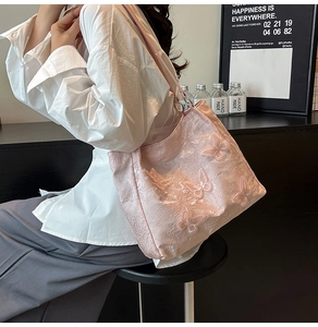 Detail der 3D-Schmetterlingsstickerei auf rosa Tragetasche mit strukturierter Textur