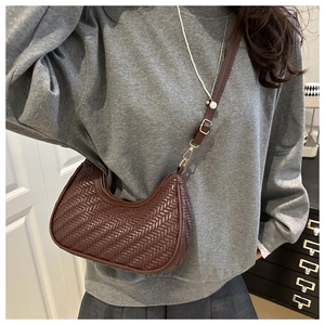 Detailed view of brown woven hobo bag showing intricate texture and adjustable strap