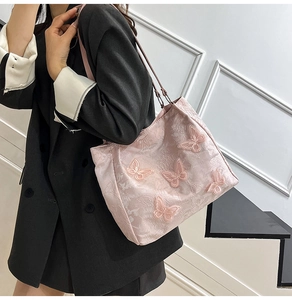 Detail der eleganten rosa Tragetasche mit exquisiter 3D-Schmetterlingsstickerei und Seidentextur