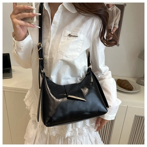 Chic black faux leather shoulder bag with adjustable strap and gold metal clasp