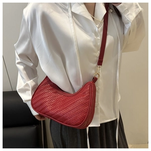 Detail of red woven leather hobo bag showing intricate texture and gold buckle