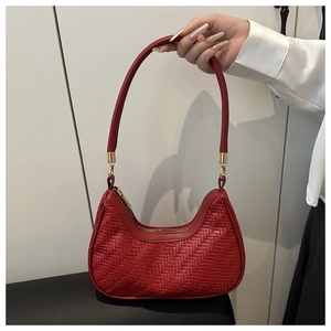 Detail of dark red woven hobo bag with gold hardware and intricate leather texture