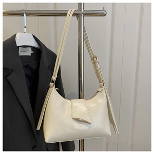 Detail of cream white underarm bag with asymmetric triangle metal buckle and matte PU leather