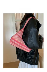 Detailed close-up of pink and orange striped woven fabric on a large bucket shoulder bag