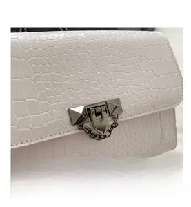 Close-up of white crocodile pattern PU leather with metal rivet chain buckle details