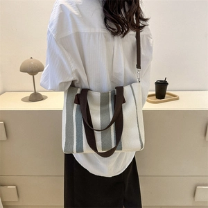 Minimalist striped canvas tote bag with brown straps for daily commuting and shoulder wear