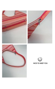 Detail of colorful woven straw bucket bag showing metal studs and smooth zipper