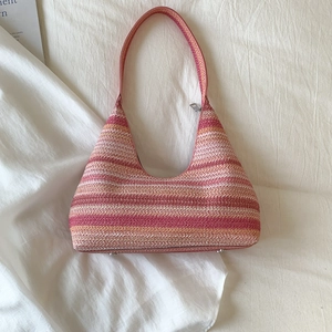 Detail of pink and orange gradient woven hobo bag with protective metal feet and zipper
