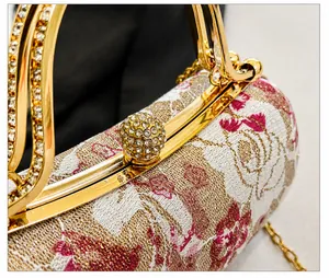 Detailansicht des goldfarbenen Verschlusses mit glitzernden Strasssteinen auf der Tasche