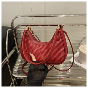 Detail of dark red woven leather hobo bag with gold hardware and intricate textures