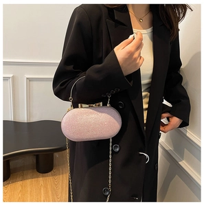 Detailed view of pink glitter evening bag with gold metal handle and bow clasp