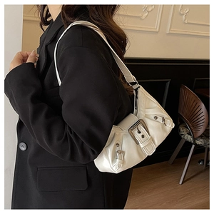 Detail of white Y2K shoulder bag with glossy finish and vintage metal buckles