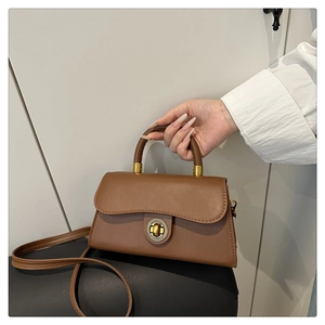 Detailaufnahme der braunen Umhängetasche mit goldenem Drehverschluss im Vintage-Stil