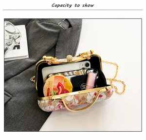 Detailansicht der Innenkapazität der floralen Abendtasche mit Kette und Perlenverschluss