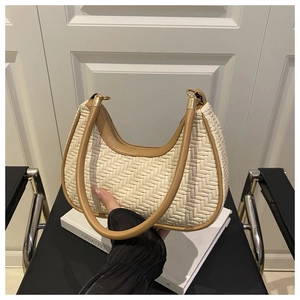 Detailed close-up of woven hobo bag texture with brown handles and golden zipper