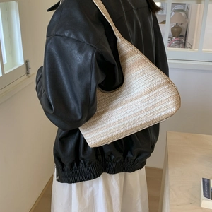 Chic woven bucket hobo bag featuring neutral stripes for stylish summer beach vacations