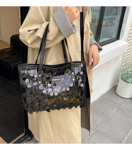 Close-up of black sequined tote bag featuring Creative Cat leather patch and sleek handles