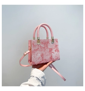 Detailansicht der pinkfarbenen Handtasche mit Marmormuster und gewebten Tragegriffen