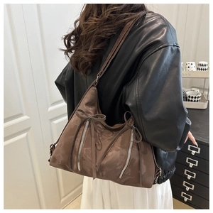 Rear view of model wearing a vintage brown suede tote bag with ribbon and zipper details
