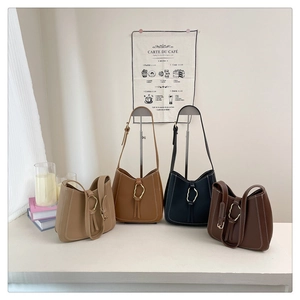 Detail view of four PU leather underarm bags in various colors with metal rings and tassels