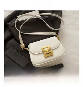 Detailed view of white saddle bag with gold geometric lock and phone size comparison
