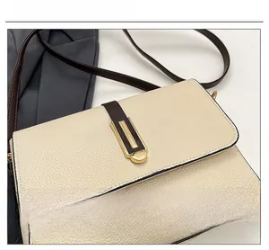 Detail of lychee pattern leather shoulder bag with golden metal buckle and brown strap