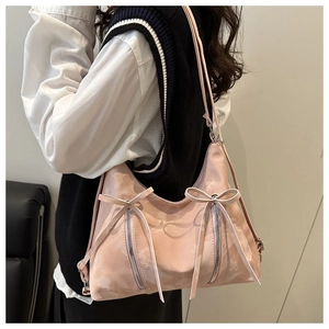 Detailed side view of pink hobo tote bag featuring side bow knots and zipper accents